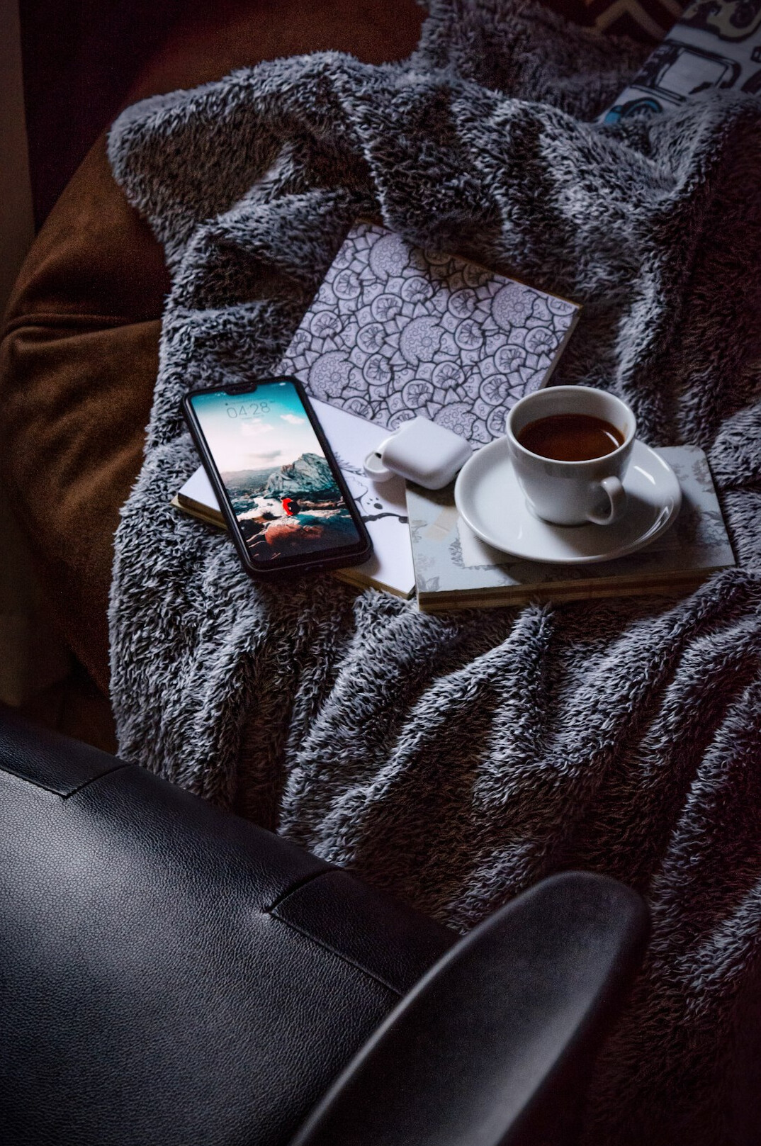 Tablet showing a digital magazine on a cozy armchair next to a cup of tea